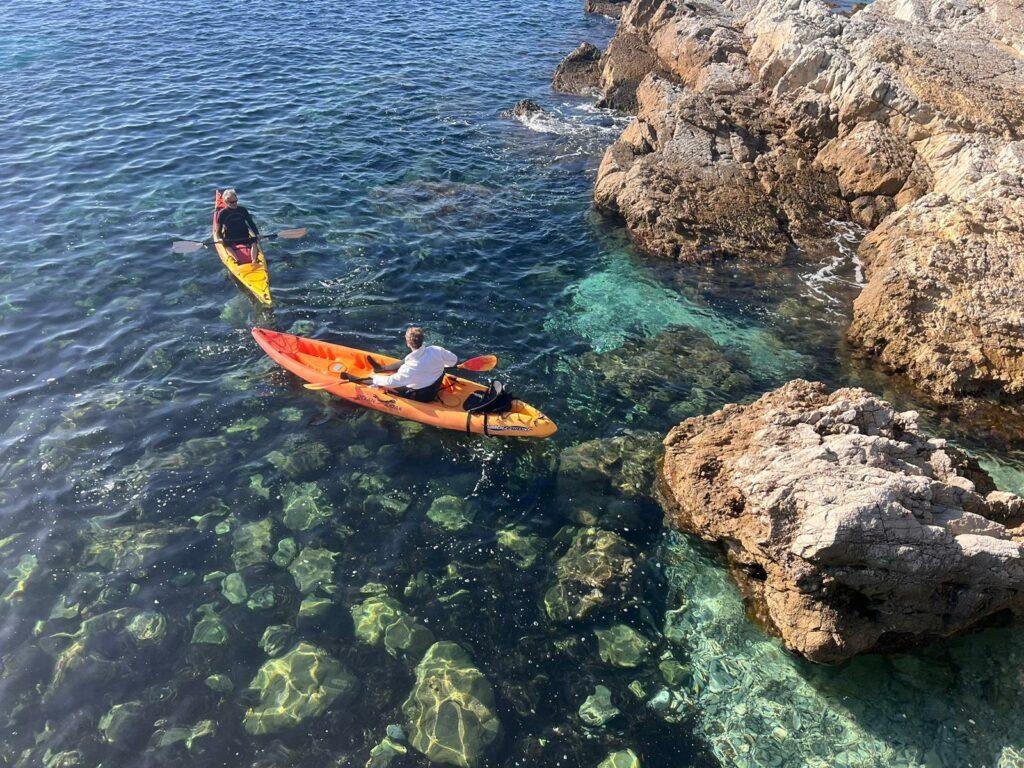 Kayak au raz des cailloux dans une eau cristalline.